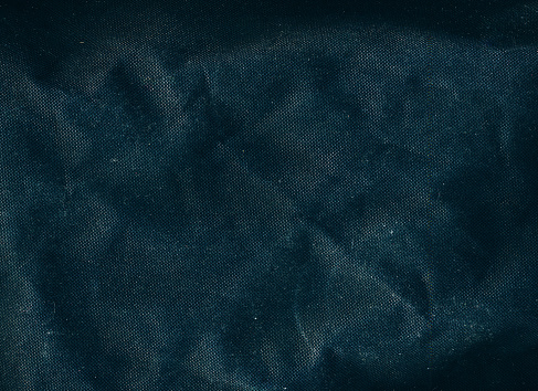Creased texture. Grain noise. Worn fabric overlay. Dust scratches defect on dark wrinkled uneven textile surface illustration abstract background.