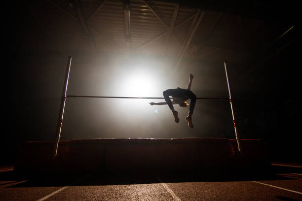 View from below of an athlete running fast in a race on the athletics track.