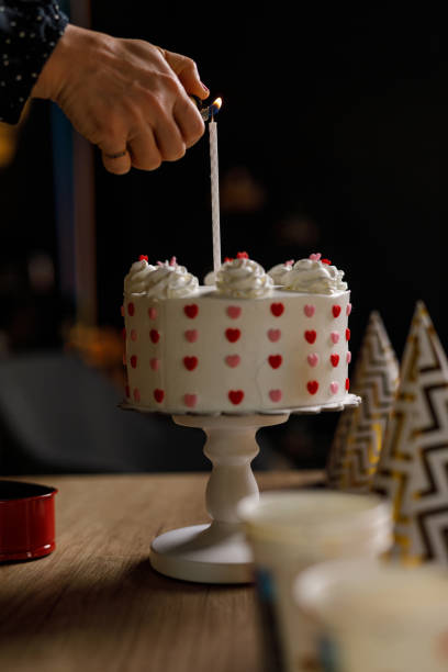 istock Woman using a lighter and lighting a birthday candle on a cake 1502674699