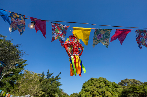 Balloons and hanging flags form a multicolored scene and decorate an outdoor party. Traditional Brazilian June festival.Brazilian party decoration.