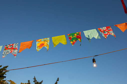hanging flags form a multicolored scene and decorate an outdoor party. Traditional Brazilian June festival.Brazilian party decoration. Selective focus