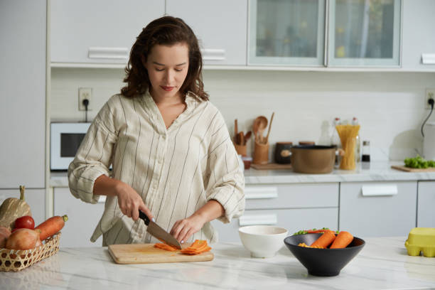 istock Woman Cutting Carrots in Mactchsticks 1502701771
