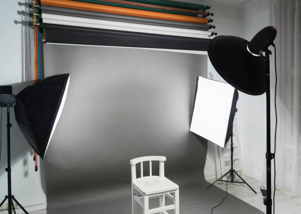 istock Photo studio lighting set up: white chair, paper backgrounds, studio equipment and lighting fixtures 1502702946
