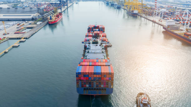 istock Tugboat pull container cargo ship vessel to cargo international container yard port concept shipping by sea. Freight shipping Cargo container box to customs Port. 1502702992