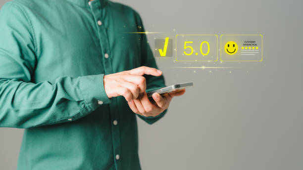 istock Customer using a mobile phone to rate service satisfaction with virtual screens on smile face icon. Comment scores are very impressive. Customer service assessment, testimonial, and feedback. 1502704815