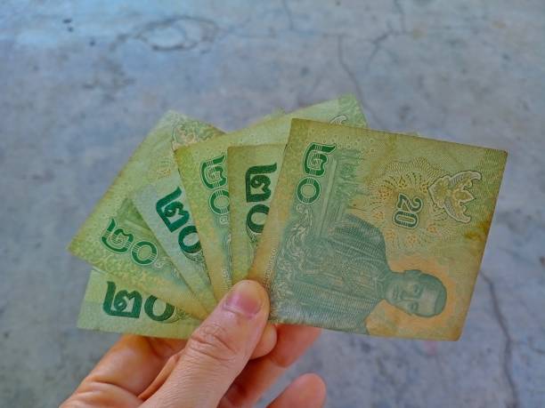 istock Hand holding a Thai money,20 baht 1502708480