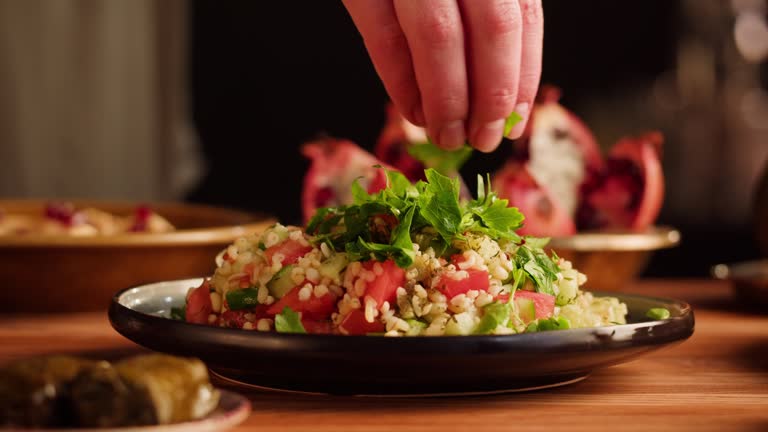 Tabbouleh Vegetable Salad close-up, middle eastern national traditional food. Muslim family dinner, Ramadan, iftar. Arabian cuisine, hummus and dolma dish on table.