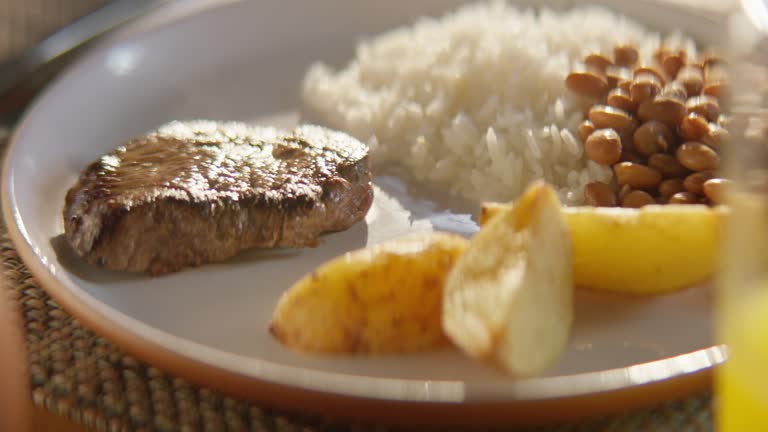 closeup of plate with rice, beans, potato and steak