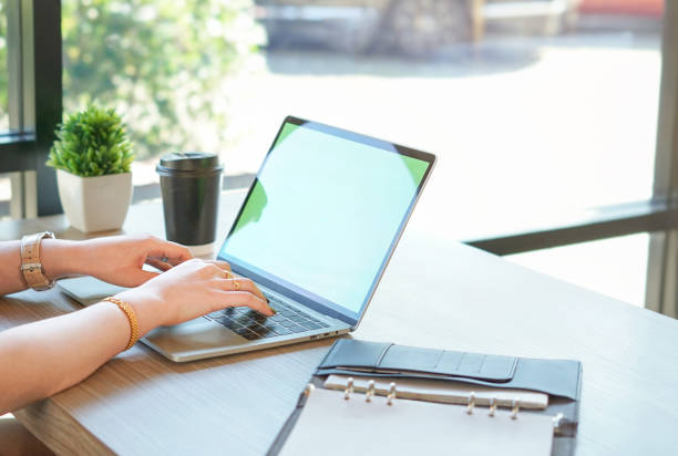 istock Business woman typing laptop with coffee cup and note book on table 1502730819