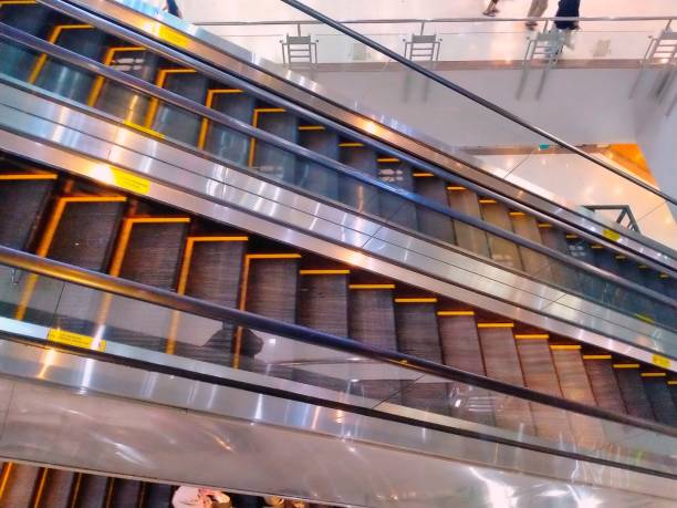 marches sur un double escalier mécanique - railroad station escalator staircase steps photos et images de collection