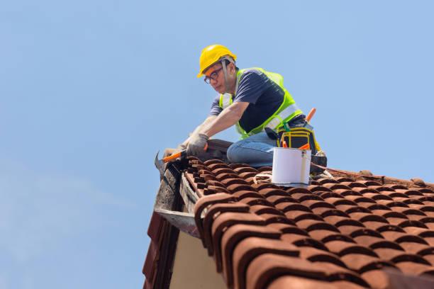 Worker man repairing eaves and tile of the old roof. stock photo