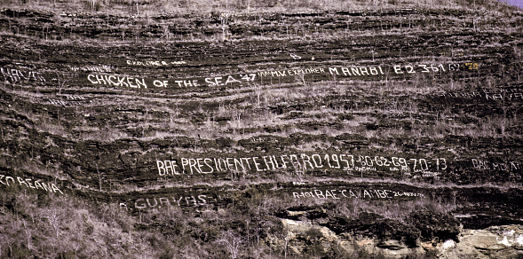Tagus Cove on Isabela Island in the Galapagos Islands has graffiti that has been carved into the rock walls by visitors over the past centuries; this happened just before the Galapagos National Park was established in 1959-1960.