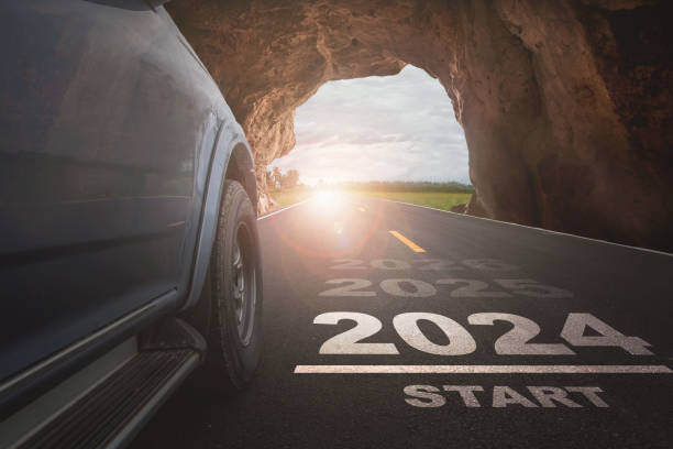 feliz año nuevo 2024,2024 simboliza el comienzo de un nuevo año. el comienzo de los coches corriendo en la carretera con el objetivo de éxito de la luz del atardecer - beginning of life fotografías e imágenes de stock