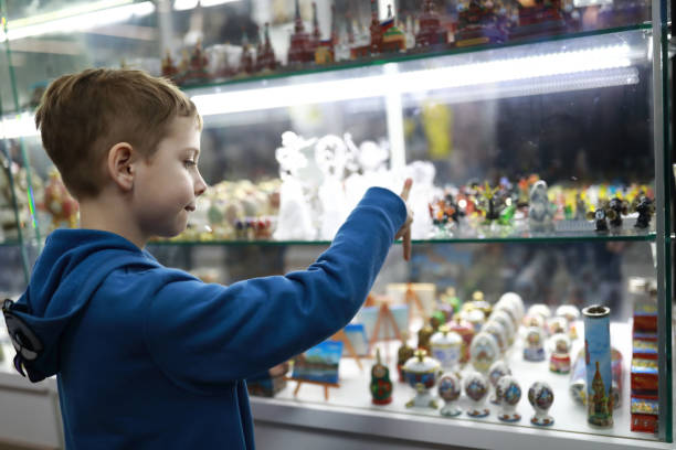 ребенок выбирает сувенир в витрине магазина - market market stall shopping people стоковые фото и изображения