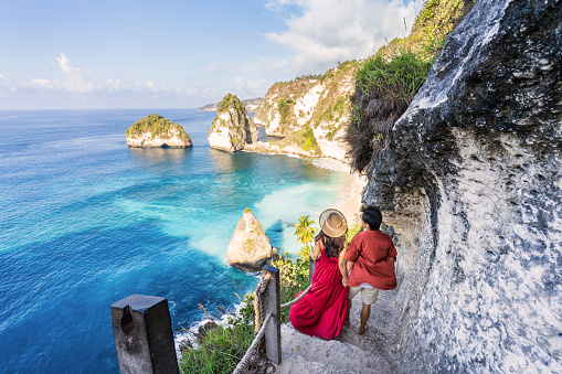 Young couple traveler relaxing and enjoying the beautiful view at diamond beach in Nusa Penida island, Bali