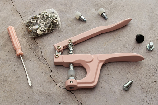 Stud crimper pliers tool set isolated on marble table.