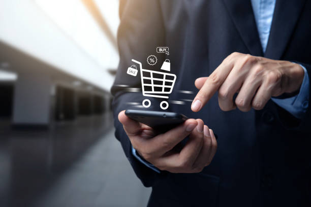 istock Young man using smartphone with shopping cart icon. 1502764422