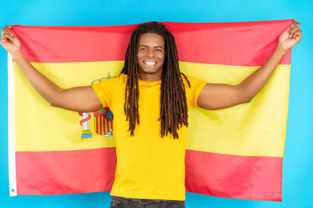 istock Happy latin man with dreadlocks raising a spanish national flag 1502767765