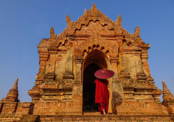 A young monk standing at Buddhist pagoda in Bagan, Myanmar.