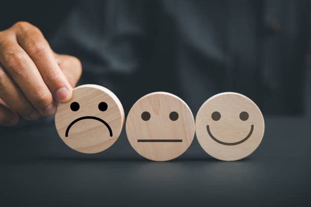 istock Unsatisfied customer holding frown icon on wooden circle 1502770459