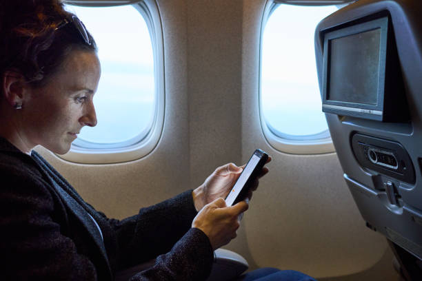 istock Young woman travelling in airplane using mobile phone 1502772832