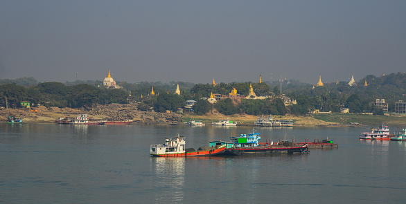 Mandalay, Myanmar - Feb 10, 2017. Cargo boats on the Irrawaddy River in Mandalay, Myanmar. Irrawaddy is the country largest river and most important commercial waterway.