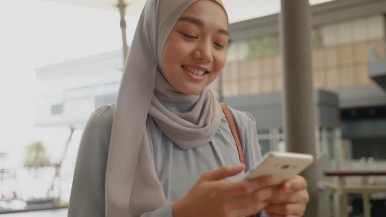 muslim woman using smart phone to talk business outdoors, borderless communication concept, internet everything.