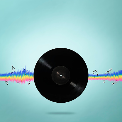Close-up of blank LP vinyl record with sound equalizer wave line and musical notes against light blue background.