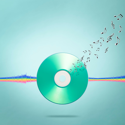 Close-up of blank music CD with sound equalizer wave line and flying musical notes against light blue background.