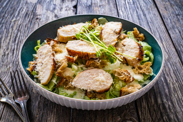 istock Caesar salad  - vegetable salad with roast chicken breast on wooden table 1502777735