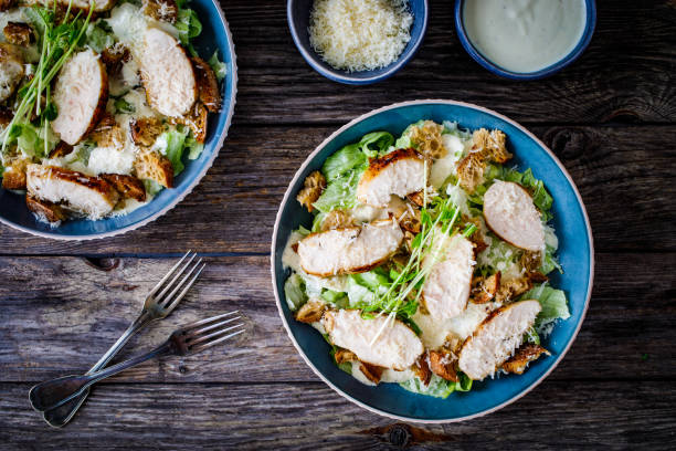 Caesar salad  - vegetable salad with roast chicken breast on wooden table