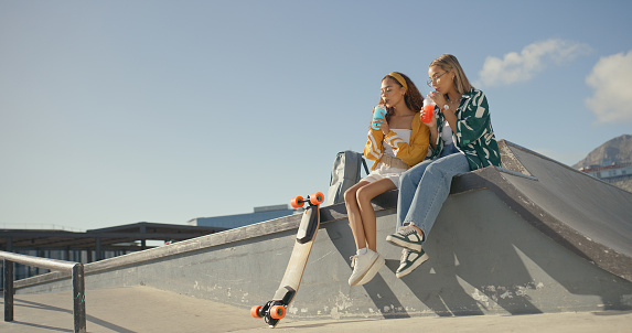 Relax, drink and summer with friends at skate park for bonding, happiness and hipster. Mockup, happy and teenager with women and skateboard in outdoors for skating, fitness and training together