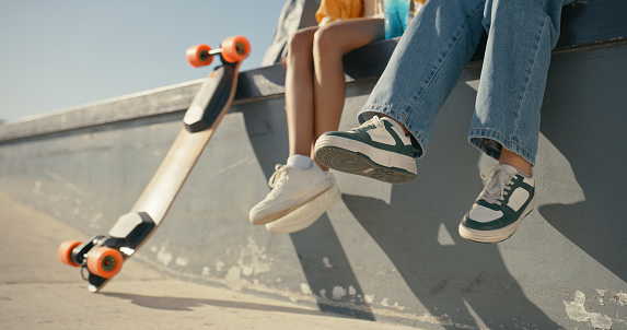 Friends, women and shoes at a skate park outdoor in summer for fun, sports and skating. Closeup of female people together with casual clothes and a skateboard for freedom, travel adventure and break