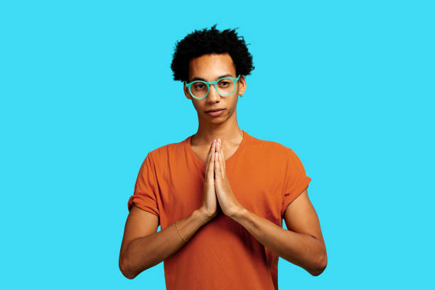 istock Man meditating with clasped hands, eyeglasses, looking at camera 1502790414