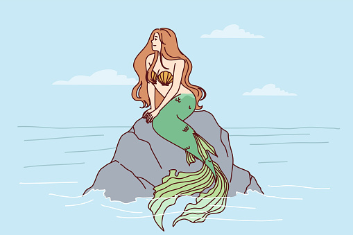 Mermaid sits on sea rock to illustrate fairy tales about ocean dwellers and magical creatures living underwater. Beautiful mermaid girl with fish tail and shell bra looks to side in search of ships