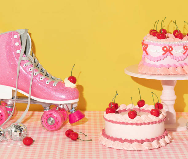 Summer creative layout with pink roller skate with whipped cream and bright red cherry, vintage cakes, disco balls, and cherries on pastel pink plaid and yellow background. 80s or 90s retro aesthetic idea. Minimal summer fashion girl idea.
