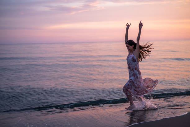 istock Happy woman running through sea on the beach 1502801862