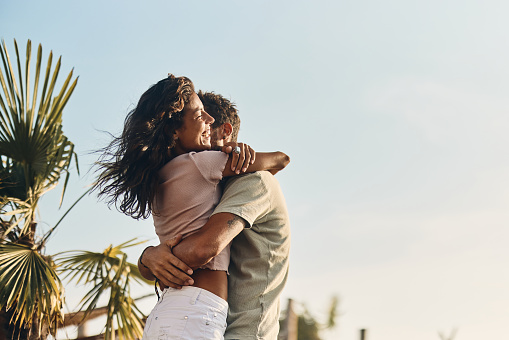 Happy young couple running together on beach