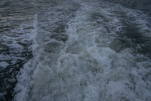 The passenger ship is sailing at sea, with the surging sea water