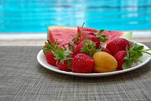 Assorted fruit on a plate at the poolside