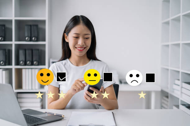 istock Woman holding a digital smartphone with checkboxes rating smiley faces excellent for Satisfaction Survey, Happy Client Customer Experience concept. 1502831289