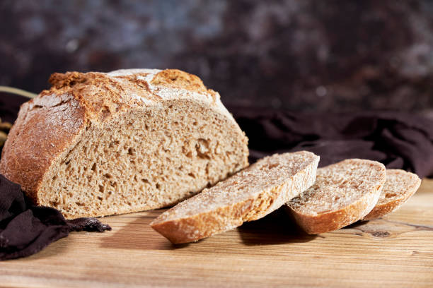 istock Golden bread next to ears of wheat on a table 1502836449