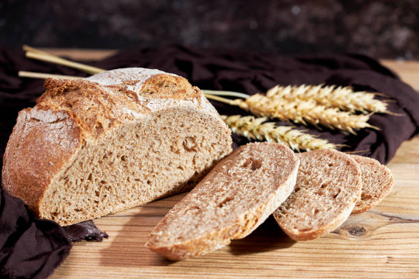 istock Golden bread next to ears of wheat on a table 1502836451