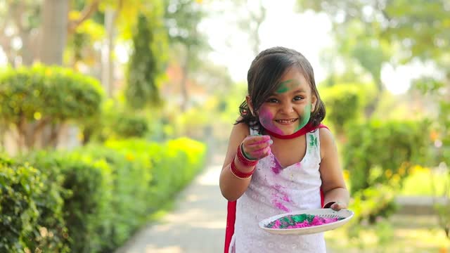 Small girl celebrating Holi festival( Festival Of Colors)