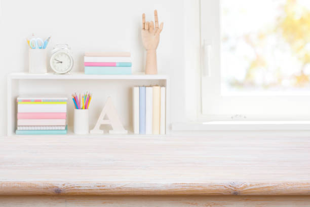 istock Empty wooden table in blurred room with bookshelf and window 1502839288