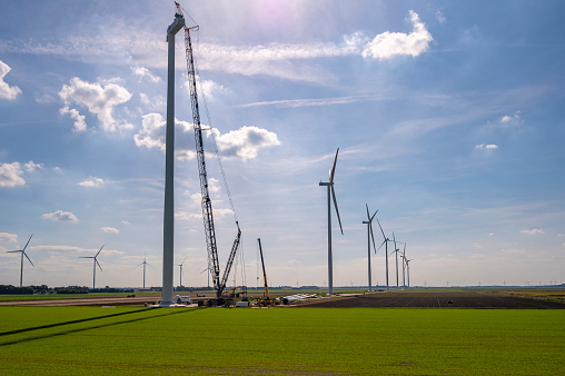 Wind turbine construction with huge cranes at a new wind park in Flevoland, Netherlands.