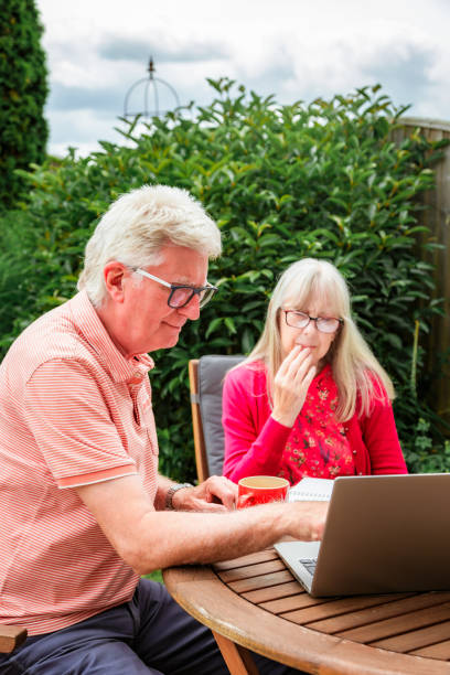 istock Senior couple checking finances outdoors in garden 1502843382