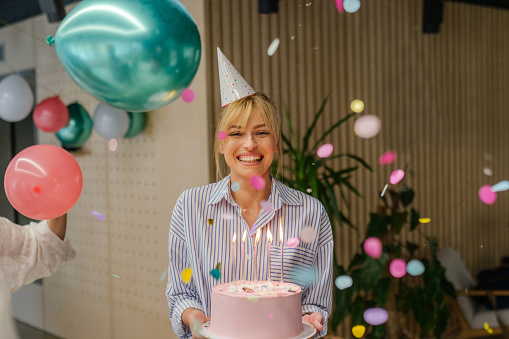 Photo of a young woman celebrating her birthday in the office