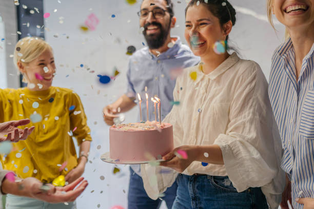 Celebrating a birthday in the office Photo of a group of coworkers celebrating a birthday in the office office birthday stock pictures, royalty-free photos & images