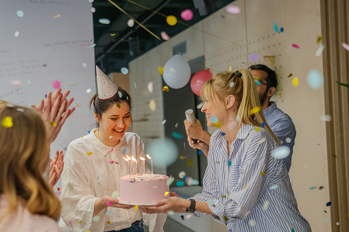 Photo of a group of coworkers celebrating a birthday in the office